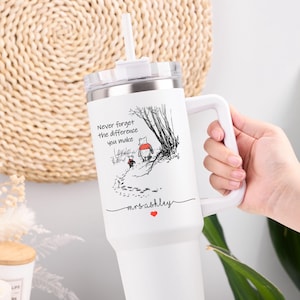 Könnte beinhalten: Weißer Becher mit Griff und Strohhalm, mit einer Schwarz-Weiß-Illustration von Winnie Puuh und Ferkel. Der Text lautet "Vergiss nie den Unterschied, den du machst" mit einem Namen und einem Herzen.