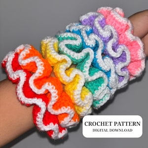 May include: A collection of colorful, handmade crochet scrunchies in a rainbow of hues, including red, orange, yellow, green, blue, purple, and pink. Each scrunchie features a wavy design with white trim. Text on the image reads "CROCHET PATTERN DIGITAL DOWNLOAD."
