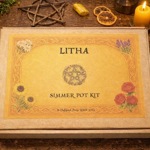 May include: A rectangular cardboard box labelled Litha Simmer Pot Kit with a central pentacle illustration, surrounded by floral graphics of daisies, sunflowers, and roses, with the text Highland Brew Witch 2024 printed at the bottom centre.