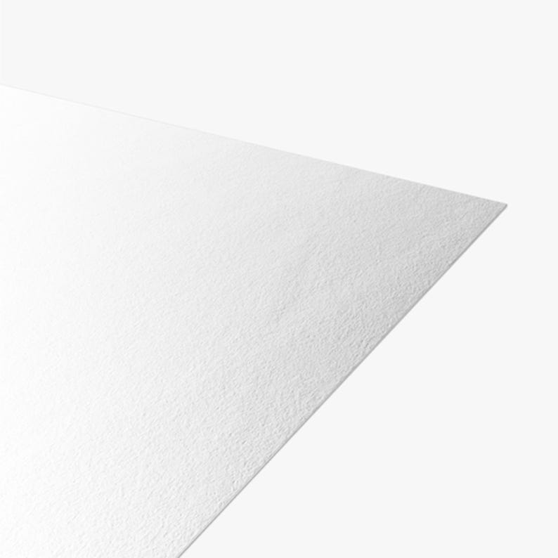 May include: A single sheet of bright white paper with a distinct, fine-grained texture visible across its surface. The paper is positioned at an angle, showing a sharp corner and a clean, straight edge against a plain, neutral background.
