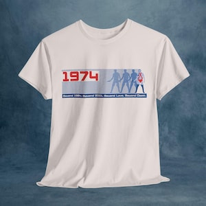 May include: White t-shirt with a blue and red graphic print featuring the year "1974" and four figures walking. The text "Beyond 1984, Beyond 2001, Beyond Love, Beyond Death" is printed below the figures.