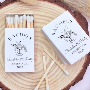 May include: White matchbox with a black and white illustration of a woman in a martini glass. The text on the matchbox reads "Rachel's Bachelorette Party Fresno, CA 2025".