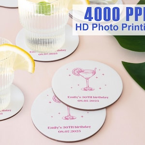 May include: White round coasters with a pink cocktail illustration and text that reads "Emily's 30TH birthday 08.07.2023". The image also shows glasses of water with lemon and mint. The text "4000 PPI HD Photo Printing" is also visible.