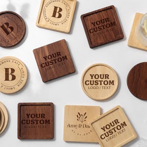 K&ouml;nnte beinhalten: Eine Sammlung von runden und quadratischen Holzuntersetzern in hellen und dunklen Holzt&ouml;nen. Mehrere Untersetzer zeigen lasergravierte Texte wie "YOUR CUSTOM LOGO/TEXT", "B", "SWEET & BAKERY HOMEMADE CAFE SINCE 2018", "Amy & Dan 07.21.2028" sowie eine florale Grafik.