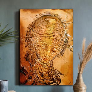 May include: An abstract artwork featuring a detailed, textured portrait of a person's face in shades of gold and brown. The artwork is mounted on a wooden frame and hangs on a teal wall. A decorative vase and plant are in the foreground.