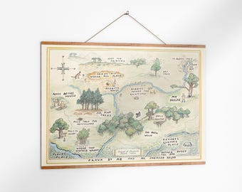 May include: A framed map illustration of a whimsical landscape with text labels like "Pooh Bear's House" and "Sandy Pit Where Pooh Plays." The map is in soft watercolor tones, with a wooden frame and a hanging string.