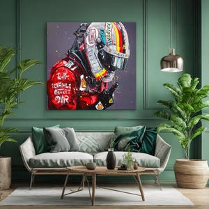 May include: A vibrant painting of a racing helmet and suit. The helmet features a colorful design with the word "KASPER" and the suit has the word "MAHLE" printed on it. The artwork is displayed on a green wall above a sofa.