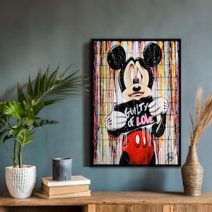 Puede incluir: Obra de arte enmarcada con Mickey Mouse sosteniendo un cartel que dice "Guilty of Love". El fondo es un diseño de pintura goteada de colores. Mickey Mouse está representado con su atuendo clásico negro, rojo y blanco.