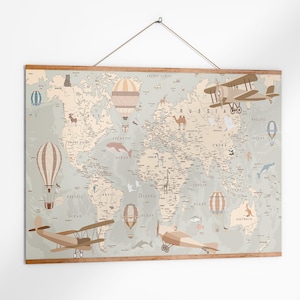 May include: A world map print with a light blue background, featuring illustrations of hot air balloons and vintage airplanes. The map is framed in wood and hangs from a string. The map shows the continents and oceans.
