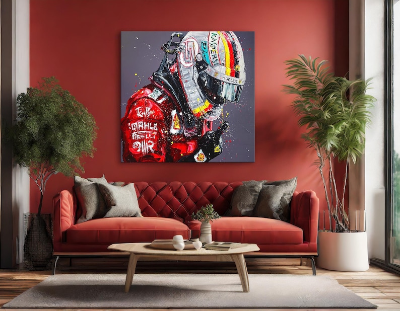 May include: A large square canvas art piece depicting a Formula 1 driver's helmet and racing suit. The artwork features a vibrant color palette with red, black, white, and yellow accents. The helmet displays sponsor logos and a colorful design. The racing suit has sponsor logos.