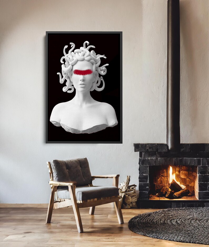 May include: A framed art print depicting a white bust of Medusa with a red band across the eyes, set against a black backdrop. The artwork is displayed in a room with a fireplace, a wooden chair, and a circular rug.