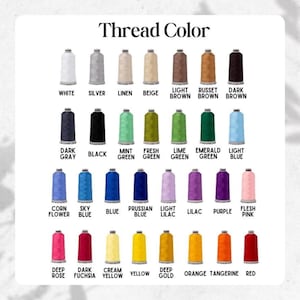 May include: A color chart titled "Thread Color" displays a variety of thread spools in various colors. Colors include white, silver, beige, brown, black, green, blue, purple, pink, yellow, orange, and red. Each spool is labeled with its corresponding color name.