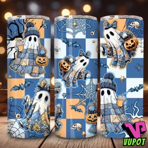 May include: Three Halloween-themed tumblers with ghost designs. Each tumbler features a white ghost with a blue and orange patchwork design, holding a pumpkin bucket or a coffee cup. The background includes bats, spiderwebs, and a checkered pattern.