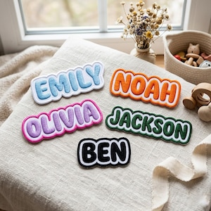 Pode incluir: Cinco emblemas bordados com nomes e bordas brancas. Os emblemas apresentam os nomes EMILY em azul claro, NOAH em laranja, OLIVIA em roxo, JACKSON em verde escuro e BEN em preto. Cada emblema tem um design de fonte estilo bolha.