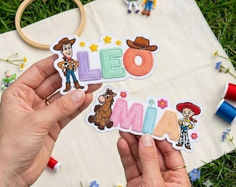 May include: Two embroidered fabric patches featuring Toy Story characters. One patch displays the name LEO in pastel letters with Woody and yellow stars. The second patch displays the name MIA in pastel letters with Bullseye and Jessie.