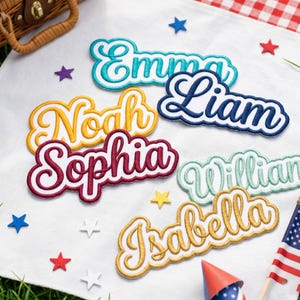 May include: A collection of embroidered name patches featuring the names Emma in teal, Liam in navy blue, Noah in yellow, Sophia in maroon, William in light green, and Isabella in gold, all displayed in a cursive font with a white border.