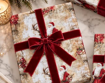 May include: Two rectangular gift boxes wrapped in vintage-style paper featuring illustrations of Santa Claus and reindeer, each tied with a deep red velvet ribbon bow. A roll of matching wrapping paper sits nearby with gold scissors.