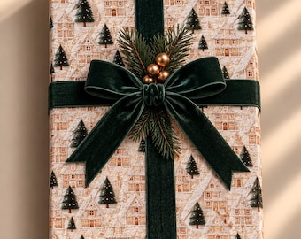 Puede incluir: Una caja de regalo rectangular envuelta en papel de color crema con un patrón repetitivo de casas de pan de jengibre y pinos de color verde oscuro. Una cinta de terciopelo verde oscuro está atada en un lazo, decorada con agujas de pino y bayas doradas.