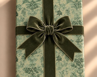 May include: A rectangular gift box wrapped in light green paper featuring a dark green intricate floral damask pattern. The package is tied with a wide, dark olive green velvet ribbon that forms a large, centered bow on the top surface.