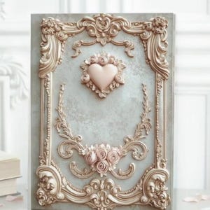 May include: A decorative wall panel with a pale blue background and elaborate gold-coloured trim. The panel features a pink heart and rose accents, creating a romantic aesthetic. The design is reminiscent of vintage decor.