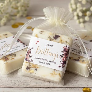 Bridal shower and wedding soap favors.  Custom designed favors with a gold mica swirl top and dried botanicals, personalized label and ivory organza bags.