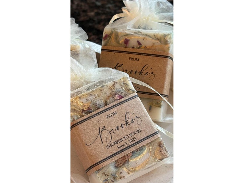 custom soap favors with gold mica top swirl and optional dried botanicals, in ivory organza bags with rustic personalized kraft labels