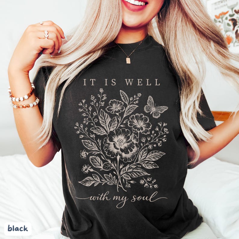 May include: Black t-shirt with a floral and butterfly design and the text "IT IS WELL with my soul" in white. A comfortable, casual style.