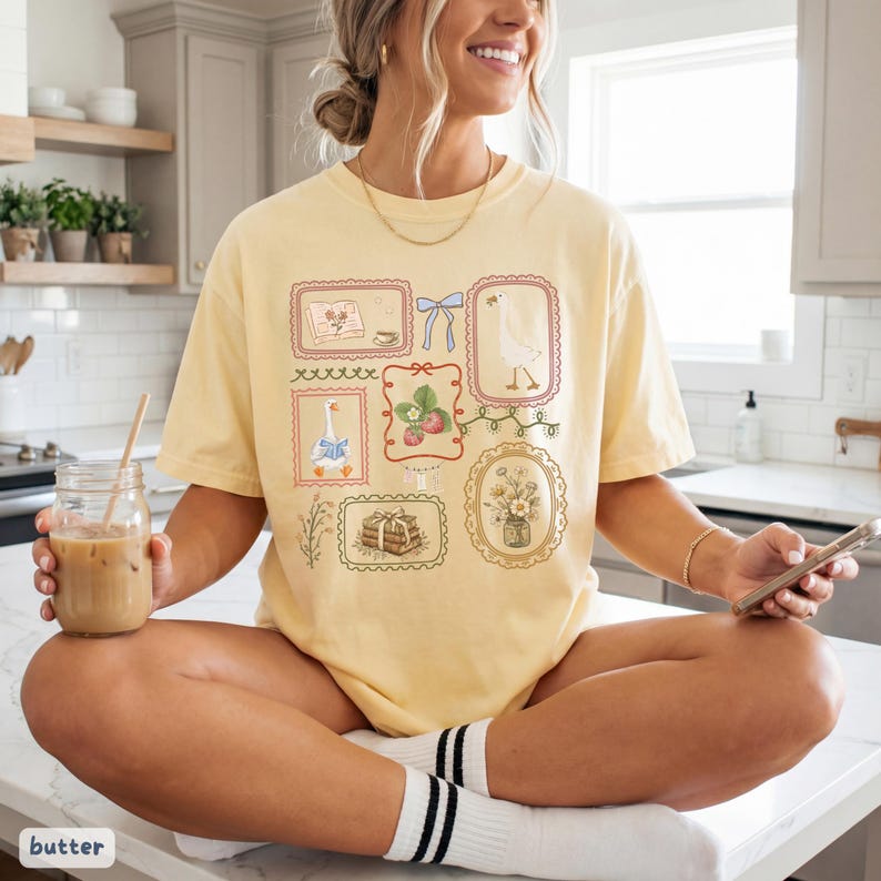 May include: A white ceramic mug with a black handle and the text "But First, Coffee" in a bold, black font. The mug is set against a blurred background, suggesting a cozy setting.