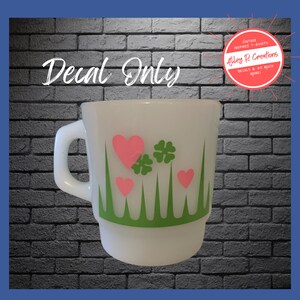 Pyrex Lucky in Love inspired decal shown on a vintage milk glass mug. Shown in lime green and pink. The decal features grass and clovers in lime green and hearts in pink. The text 'Decal Only' is written in white on a black brick background. There is an accompanying logo for Alley R Creations.