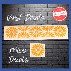 May include: Vinyl decals featuring a repeating pattern of orange daisy-like flowers. The decals are shown on a brick wall. The text "Vinyl Decals" and "Mixer Decals" is also shown on the image.