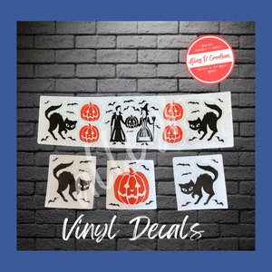 May include: Set of five Halloween vinyl decals featuring black cats, pumpkins, a witch, and a vampire. The decals are white with black and orange details. The text "Vinyl Decals" is printed below the decals.