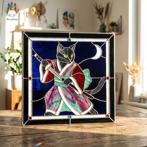May include: Stained glass panel featuring a black cat samurai with a sword, wearing a red, purple, and green kimono. The background is a deep blue with a white crescent moon. The panel is framed in black and silver.