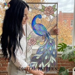 May include: A stained glass panel depicting a peacock with blue and purple plumage, surrounded by pink roses and green foliage. The artwork is framed in a rectangular shape, with the words "DIGITAL PATTERN" visible.