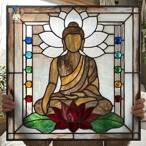 May include: A square stained glass panel featuring a central brown Buddha figure seated in a lotus position atop a red lotus flower with green leaves. A large white lotus bloom sits behind the head, flanked by vertical rows of seven colored glass gems.