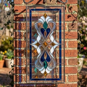 May include: A rectangular stained glass window with a dark blue border and intricate floral design. The design features white, blue, green, and gold glass pieces. The window is mounted on a red brick wall, with vines and greenery visible.