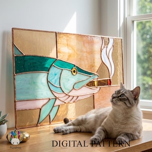 Può includere: Vetrata artistica raffigurante un pesce che fuma un sigaro, con tonalità turchese, blu e oro. L'opera è incorniciata con metallo color rame. Il testo "DIGITAL PATTERN" è in basso. Un gatto è sdraiato su una superficie di legno.