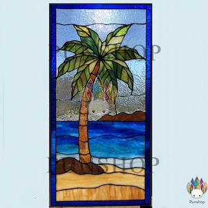 May include: Stained glass panel featuring a tropical beach scene. A brown palm tree with green fronds stands on a sandy shore, with blue ocean waves and a light blue sky. The panel is framed in a dark blue border.