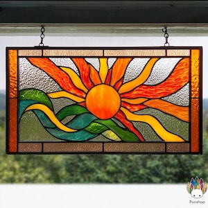 May include: Stained glass panel depicting a vibrant sunset over rolling waves. The sun is a bright orange circle with radiating orange and red rays. The waves are green and yellow. The panel is framed in a dark brown border and hangs from chains.