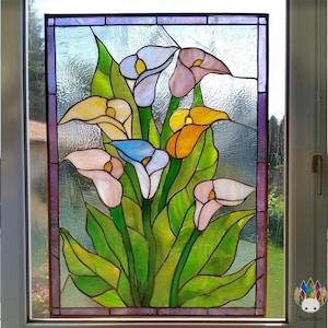 May include: Stained glass window panel featuring a bouquet of calla lilies in shades of pink, yellow, blue, and white. The flowers are set against a background of green leaves and a textured glass window. The panel is framed with a purple border.