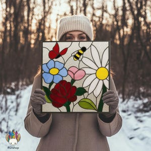 May include: A stained glass panel with a floral design, including a red butterfly, a bee, and flowers in blue, pink, red, and white. The panel is held in front of a person. The panel's design is reminiscent of a garden.