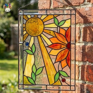 May include: Stained glass panel with a sun and flower design. The sun is yellow with orange and yellow rays. The flower is orange and red with green leaves. Blue and red beads accent the design. The panel is framed in black.