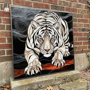 May include: A square stained glass panel featuring a white tiger with black stripes and piercing orange eyes. The tiger is depicted in a prowling stance against a dark, swirling background with a hint of red and orange at the bottom edge.