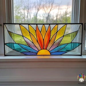 Peut inclure: Une fenêtre rectangulaire en vitrail avec un motif floral stylisé. La fleur présente des pétales aux couleurs vives : jaune, orange, violet et bleu. Le fond est en verre vert et transparent, encadré de noir.