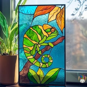 May include: Stained glass panel depicting a green and yellow chameleon on a brown branch. The background is textured blue, with orange and yellow leaves. The artwork is framed in black.