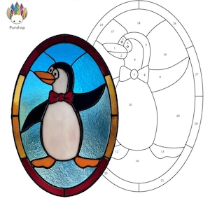 Könnte beinhalten: Ein Buntglas-Pinguin-Design mit roter Fliege, orangefarbenen Füßen und blauem Hintergrund. Der Pinguin befindet sich in einem ovalen Rahmen mit rotem, gelbem und blauem Glas. Daneben befindet sich eine nummerierte Umrisszeichnung des Designs.