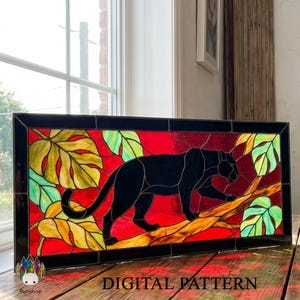 May include: Stained glass panel depicting a black panther on a branch, with a red backdrop and green and yellow leaves. The panel is framed in black, and the words "DIGITAL PATTERN" are at the bottom.