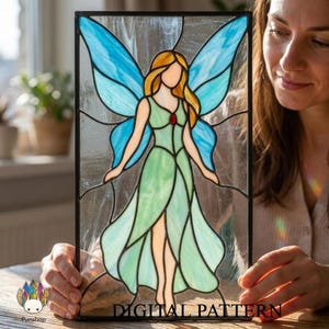 May include: A stained glass panel featuring a fairy with blue wings and a green dress. The fairy has blonde hair and a red jewel on her chest. The panel is framed in black and the words "DIGITAL PATTERN" are at the bottom.