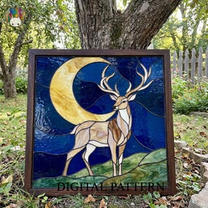 Peut inclure: Un panneau en vitrail carré dans un cadre en bois foncé représentant un cerf debout sur une colline verte devant un ciel nocturne bleu profond avec un grand croissant de lune jaune. Le texte DIGITAL PATTERN est imprimé en bas du panneau.