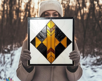 May include: A stained glass window panel with a geometric design featuring black, white, and gold colors. The design is a diamond shape with a central arrow-like pattern.