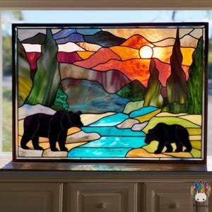 May include: Stained glass panel showing a sunset over a mountain landscape with two black bears. The artwork features vibrant colours including orange, blue, green, and purple, framed in a dark wooden border. The bears are silhouetted against the colourful scene.